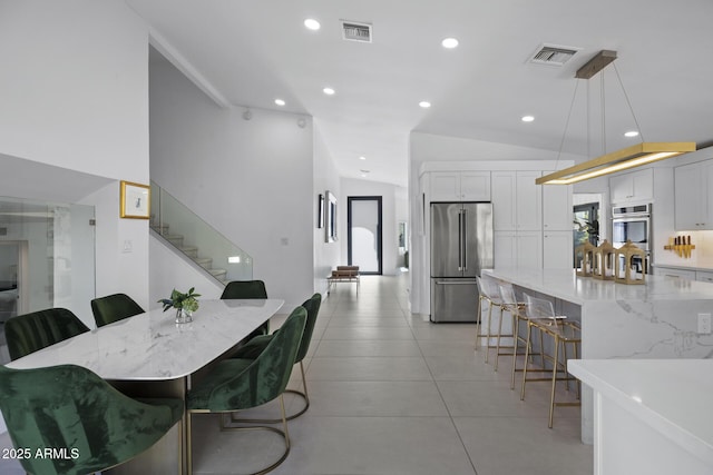 tiled dining space with lofted ceiling