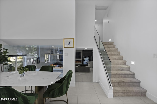 stairway featuring light tile patterned floors and a towering ceiling