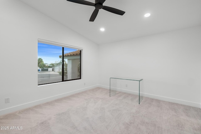 carpeted spare room featuring vaulted ceiling and ceiling fan