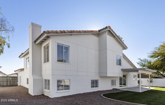 rear view of house with a patio and a lawn