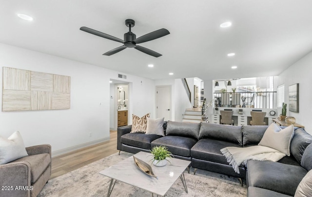 living room with light hardwood / wood-style flooring and ceiling fan