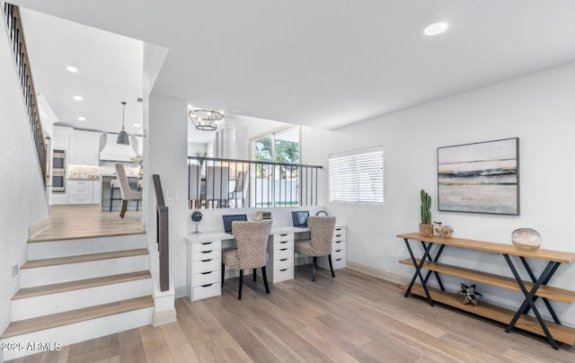 office space with a chandelier and light wood-type flooring