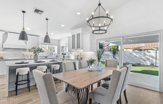 dining area with an inviting chandelier and light hardwood / wood-style floors