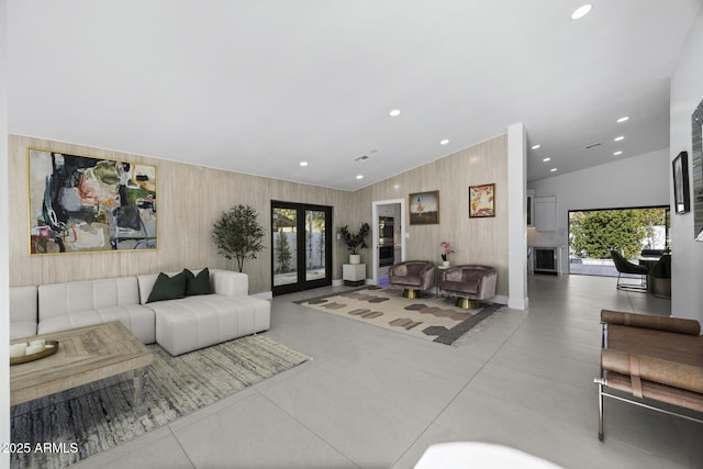 lobby with vaulted ceiling, french doors, and wooden walls