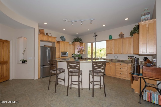 kitchen with a breakfast bar, light tile flooring, a kitchen island, and stainless steel appliances