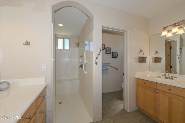 bathroom with walk in shower, vanity, toilet, and tile floors