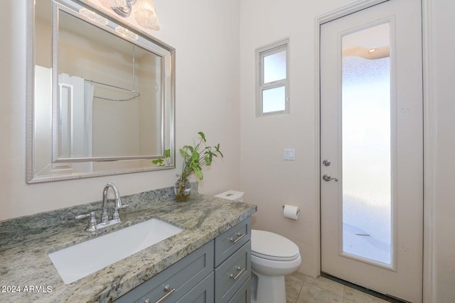 bathroom featuring oversized vanity, toilet, and tile floors