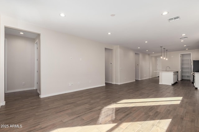 unfurnished living room featuring dark hardwood / wood-style floors and sink