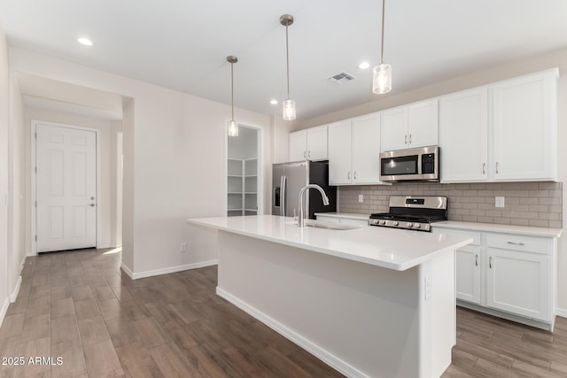 kitchen featuring sink, white cabinetry, an island with sink, stainless steel appliances, and backsplash