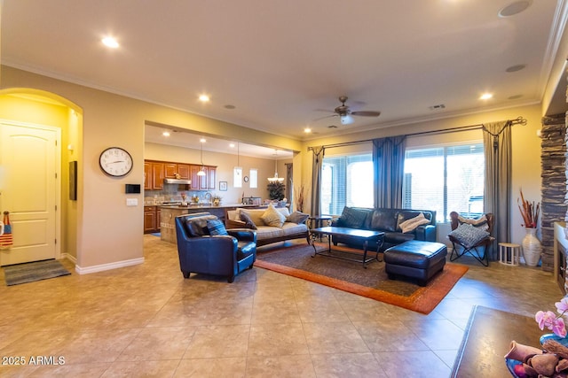 tiled living room with ceiling fan and crown molding