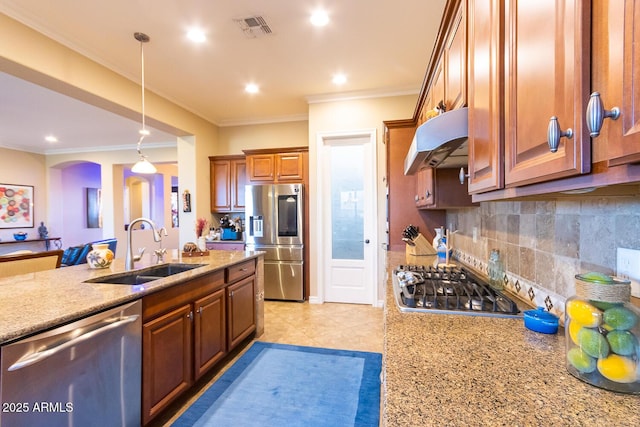 kitchen with appliances with stainless steel finishes, decorative light fixtures, light stone countertops, and sink