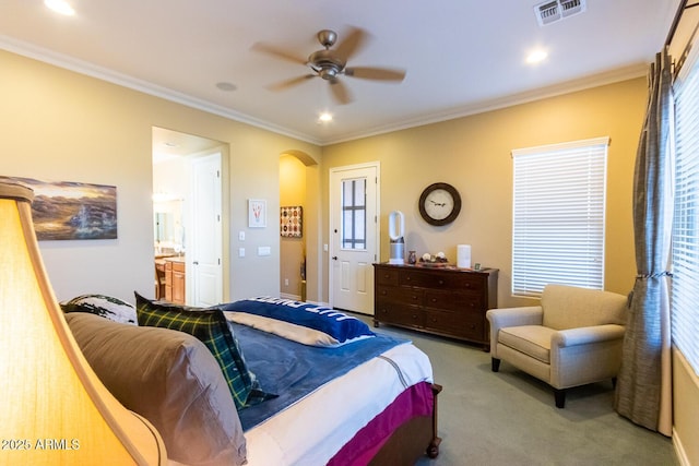 bedroom with ensuite bath, light colored carpet, ceiling fan, and ornamental molding