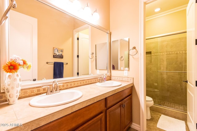 bathroom with ornamental molding, vanity, a shower with shower door, and toilet