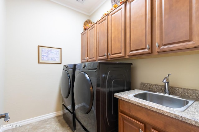 laundry area featuring sink, cabinets, washing machine and dryer, and crown molding