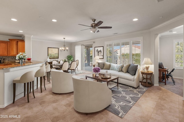 tiled living room with ornamental molding and ceiling fan with notable chandelier