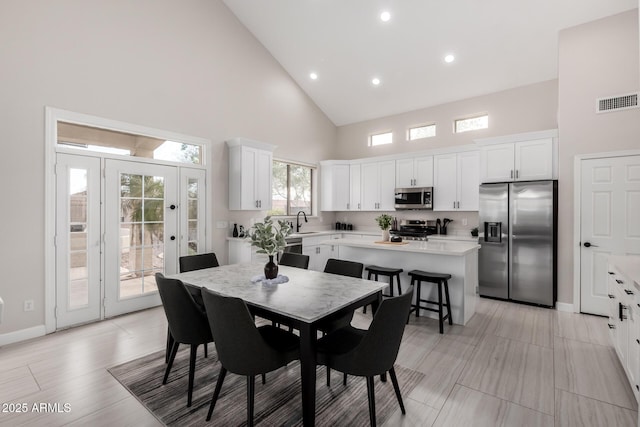 dining area with high vaulted ceiling, visible vents, recessed lighting, light wood finished floors, and baseboards