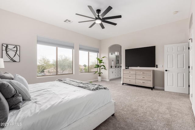 bedroom with carpet floors, visible vents, baseboards, ceiling fan, and arched walkways