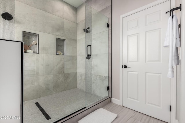 full bathroom featuring a stall shower and baseboards