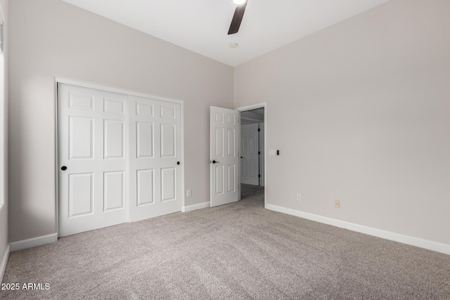 unfurnished bedroom featuring carpet flooring, a closet, baseboards, and ceiling fan