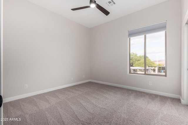carpeted empty room with visible vents, baseboards, and ceiling fan
