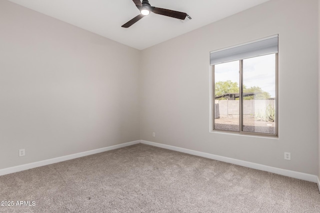 carpeted empty room with baseboards and a ceiling fan