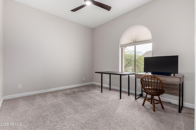 carpeted office space with baseboards and ceiling fan