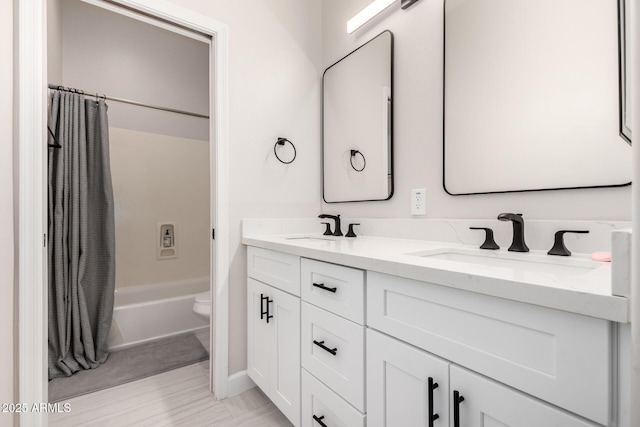 full bathroom with a sink, double vanity, toilet, and shower / bath combo
