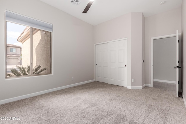 unfurnished bedroom featuring a closet, visible vents, ceiling fan, carpet floors, and baseboards