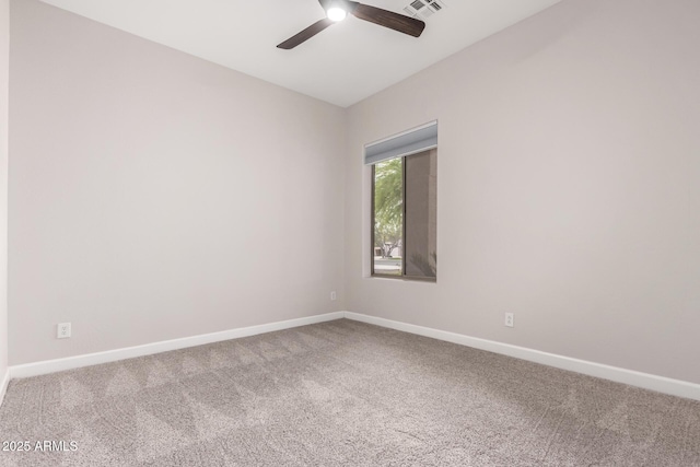 unfurnished room with a ceiling fan, baseboards, and carpet