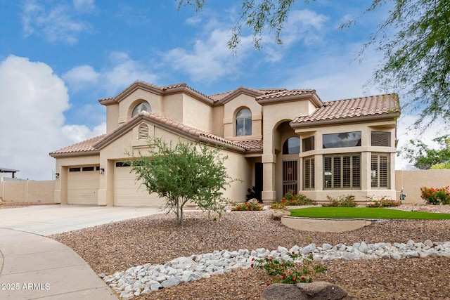 mediterranean / spanish home with concrete driveway, stucco siding, a garage, and fence