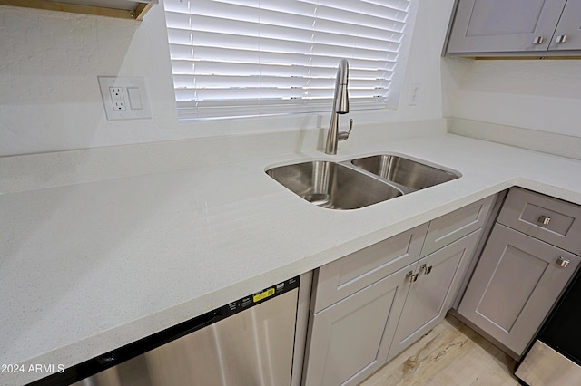 kitchen with gray cabinets, sink, and stainless steel dishwasher