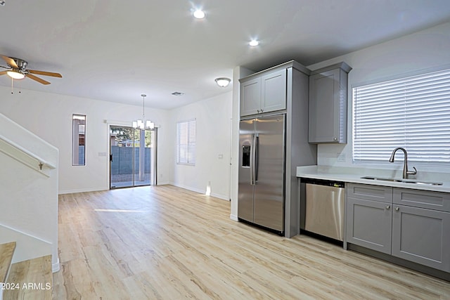 kitchen featuring ceiling fan with notable chandelier, gray cabinets, sink, and appliances with stainless steel finishes