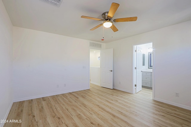 unfurnished bedroom with light wood-type flooring, ensuite bathroom, and ceiling fan