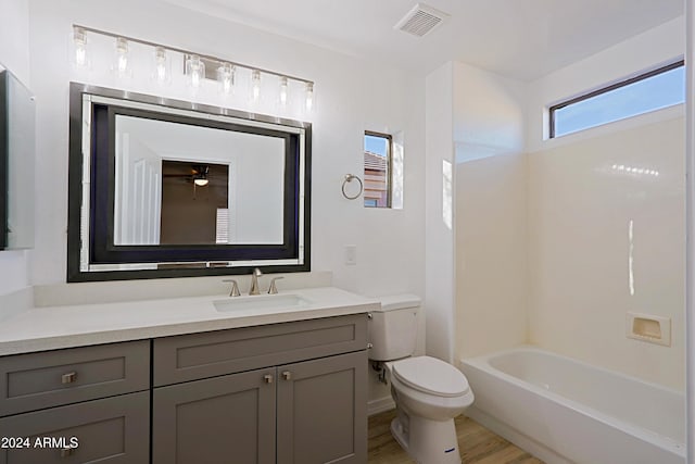 full bathroom featuring wood-type flooring, vanity, shower / bath combination, and toilet