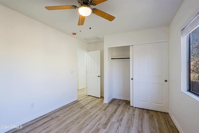 unfurnished bedroom with a closet, multiple windows, ceiling fan, and light hardwood / wood-style flooring