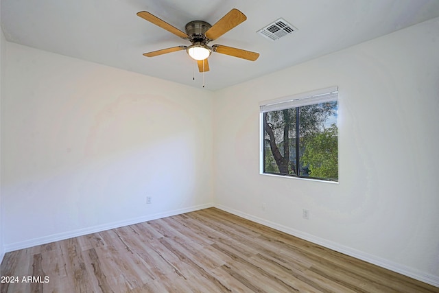 empty room with ceiling fan and light hardwood / wood-style flooring