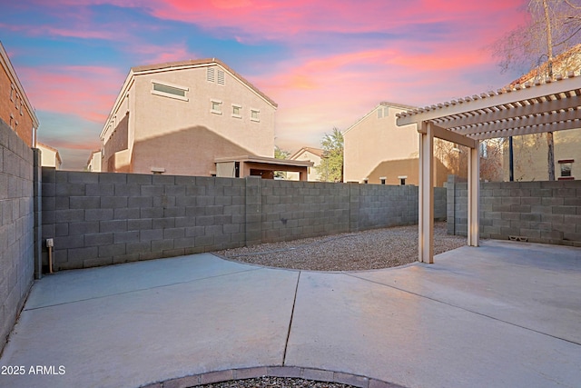 patio terrace at dusk featuring a pergola