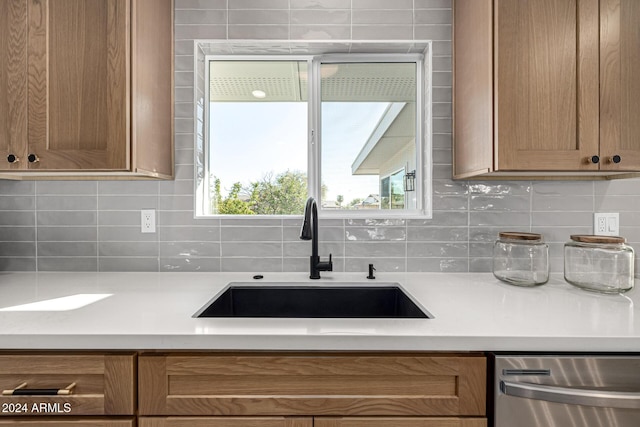 kitchen with dishwasher, sink, and tasteful backsplash