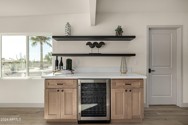 bar featuring beam ceiling, beverage cooler, and light hardwood / wood-style floors