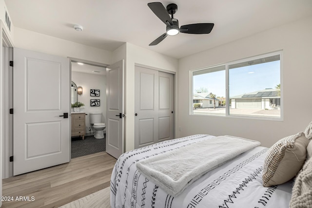 bedroom featuring connected bathroom, a closet, light hardwood / wood-style flooring, and ceiling fan