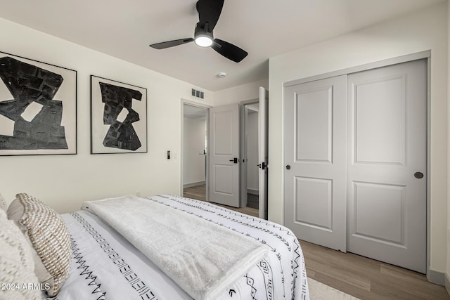 bedroom with ceiling fan, a closet, and light hardwood / wood-style flooring