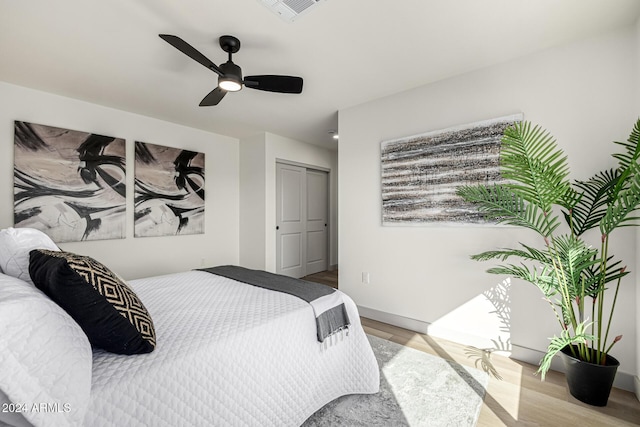 bedroom featuring light hardwood / wood-style flooring, a closet, and ceiling fan