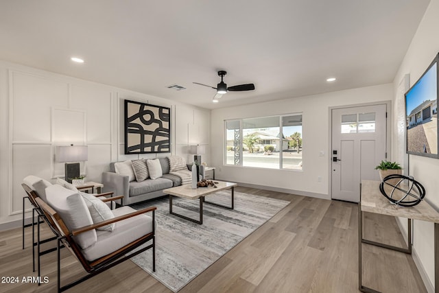 living room with light hardwood / wood-style flooring and ceiling fan