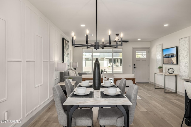 dining space with a notable chandelier and light hardwood / wood-style floors