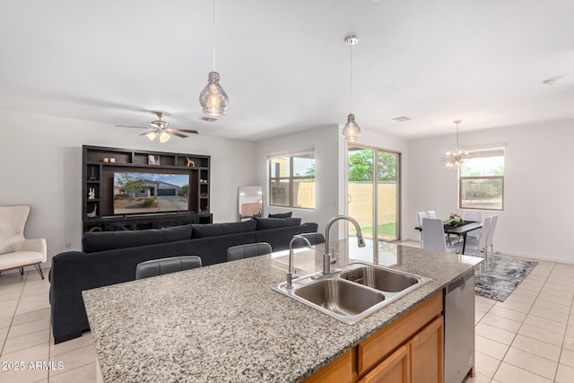 kitchen with stainless steel dishwasher, light tile patterned floors, open floor plan, and a sink