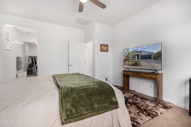 carpeted bedroom featuring visible vents, baseboards, ceiling fan, and a spacious closet