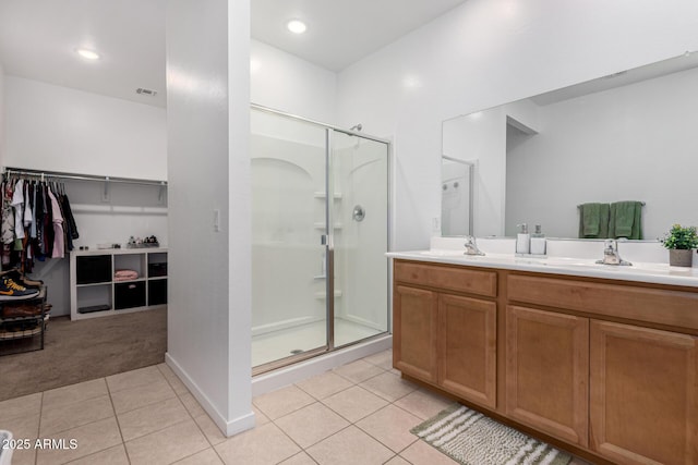 full bathroom featuring tile patterned flooring, a sink, double vanity, and a shower stall