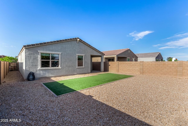back of property featuring a fenced backyard and stucco siding