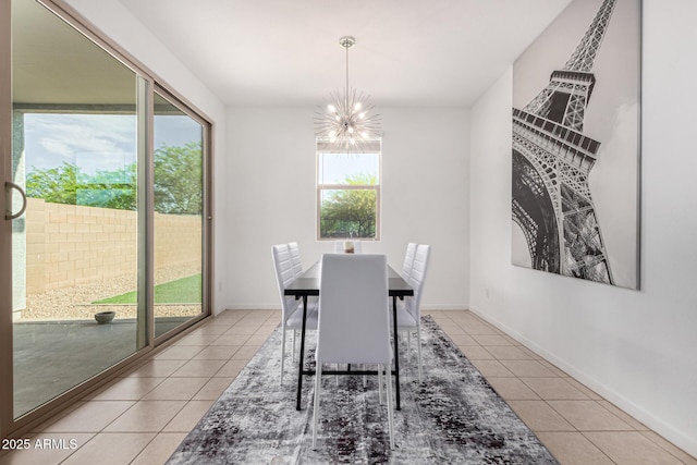 dining space with baseboards, light tile patterned floors, and a chandelier
