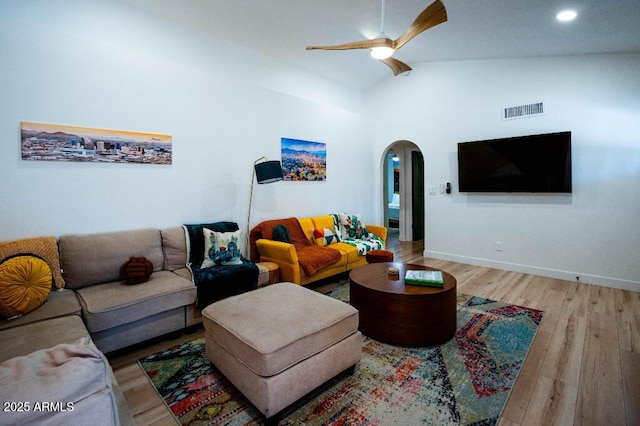 living room featuring ceiling fan, high vaulted ceiling, and light hardwood / wood-style flooring